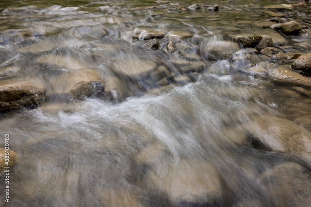 Photo of nature - Long exposure of a mountain stony creek inside in the forest. Small mountain rocky river.