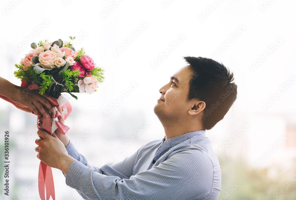 Adult asian man give a flower bouquet to girlfriend in romantic date.