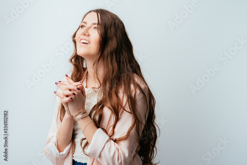 on a gray background young girl prays