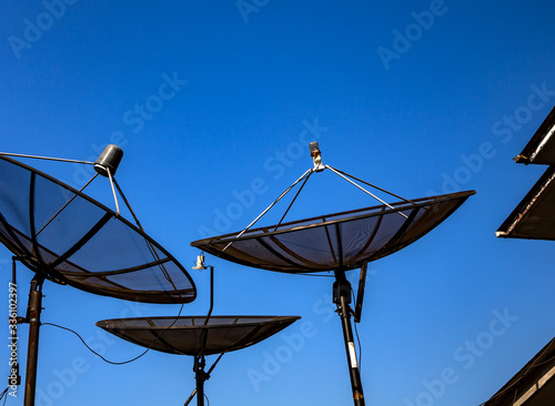 Bild auf Leinwand Parabolic satellite antenna on blue sky background closeup