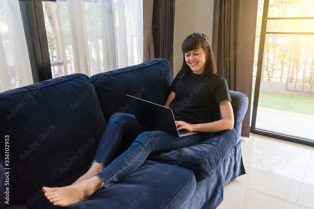 Young woman relex time working with laptop on sofa at home. Work from home concept.