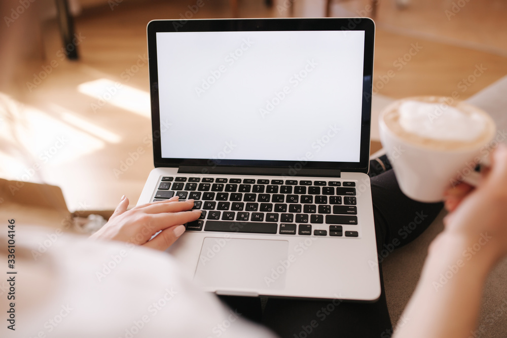 First person view of female working at home. Woman work on laptop and drink cappuccino. Mock up, white screen. Quarantine time First person view of female working at home. Woman work on laptop and drink cappuccino. Mock up, white screen. Quarantine time