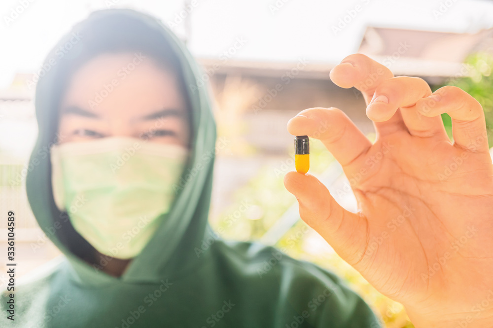 Coronavirus Covid-19 virus and Air pollution pm2.5 concept., A young man wearing a mask with a pill treatment., The young man is studying medicine, By focusing on medicine., Treatment tablets. Coronavirus Covid-19 virus and Air pollution pm2.5 concept., A young man wearing a mask with a pill treatment., The young man is studying medicine, By focusing on medicine., Treatment tablets.