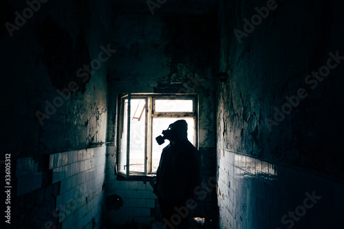 Dramatic portrait of a man wearing a gas mask in a ruined building. 