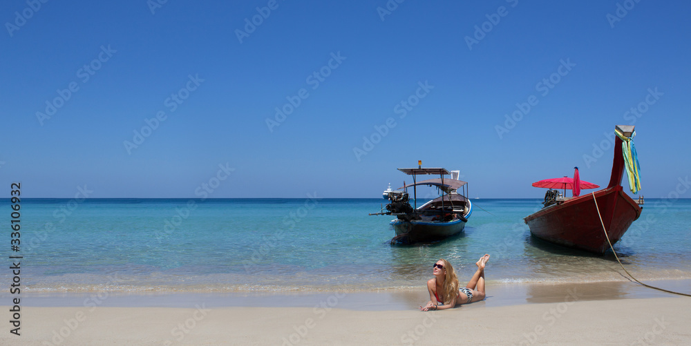 Beautiful nature landscape of Phuket island with traveler woman joy relaxing on beach near the boat. Tourism destination place Asia. Tourist girl on summer holiday vacation trip.
