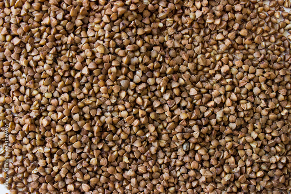 The texture of dry buckwheat. Background image of buckwheat porridge. The texture of dry buckwheat. Background image of buckwheat porridge.