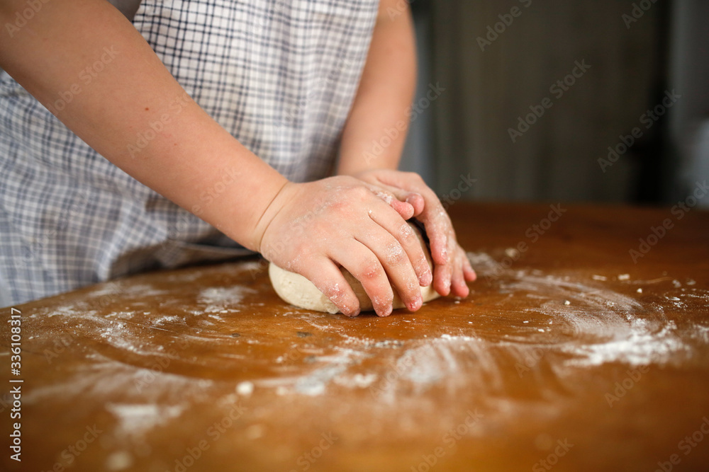 Children's hands make a dough. help mom