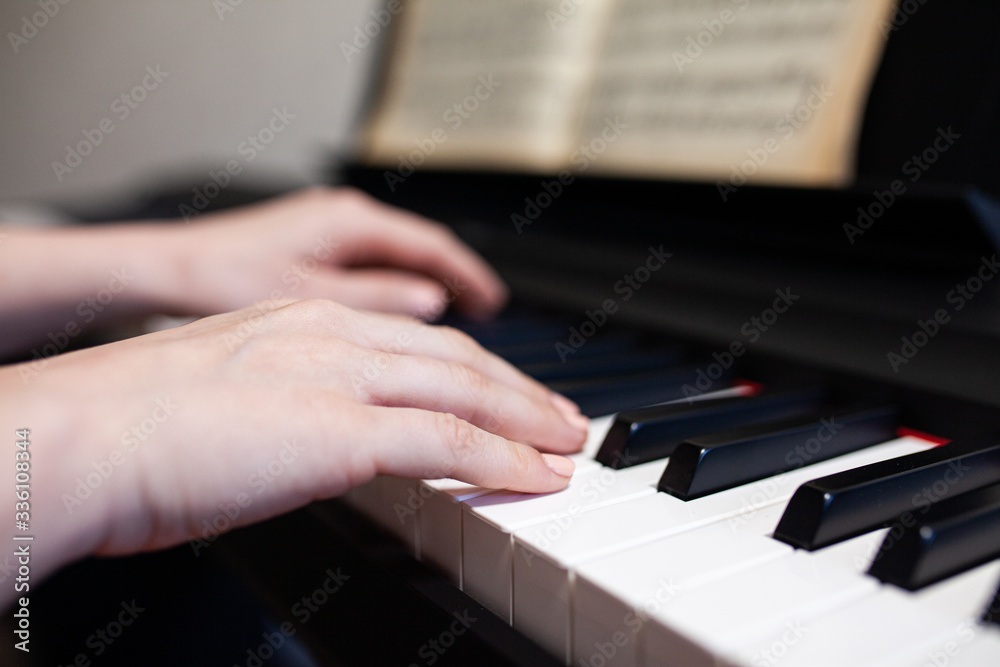 Woman hand's playing on the piano close up