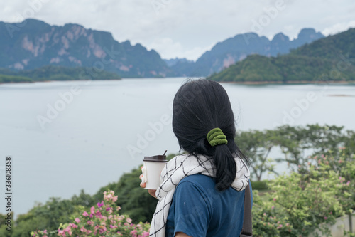 Asia woman stand and looking nature water mountain in cloudy day