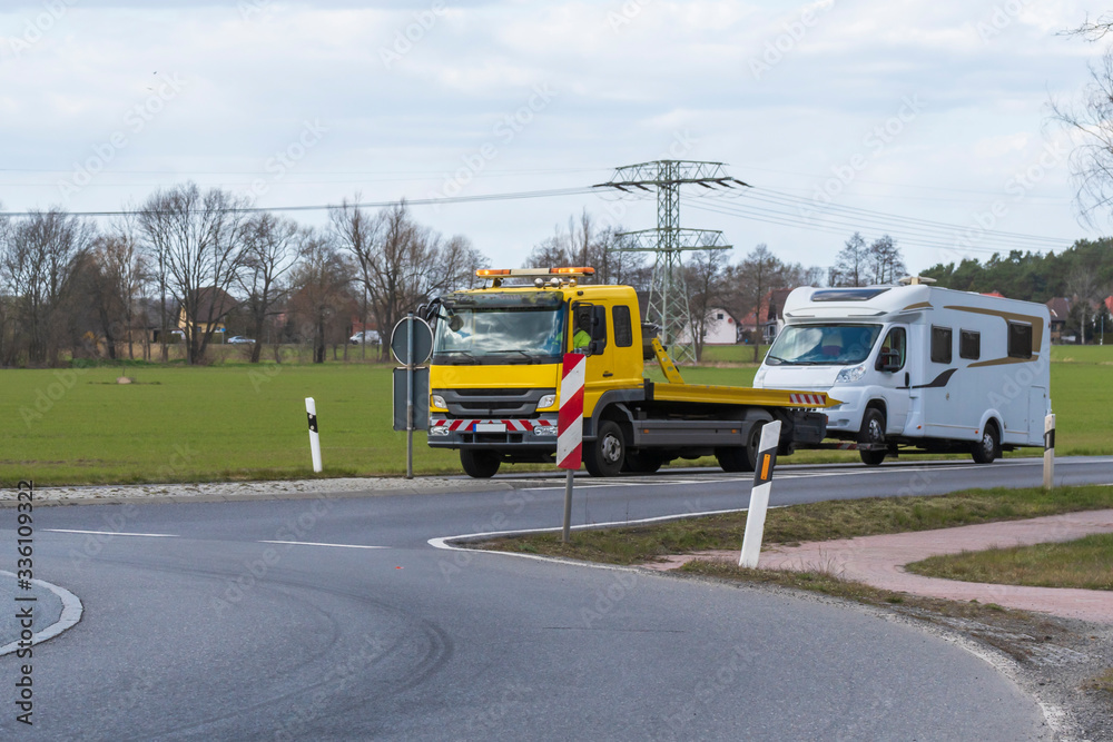 Ein Abschleppwagen mit einem Wohnmobil fährt in den Kreisverkehr ein