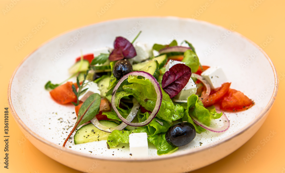 Salad of greens, red onions, slices of cheese and olives Salad of greens, red onions, slices of cheese and olives