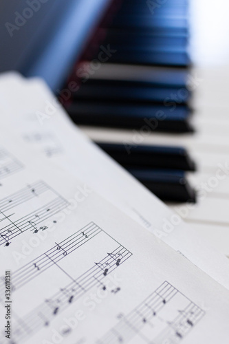 Piano and modern music sheets close up