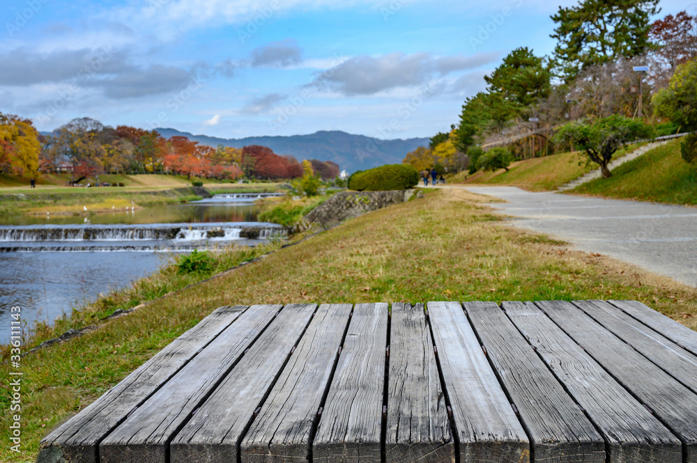 Wood table top and blurred autumn landscape of Kyoto, Japan. Wood table top and blurred autumn landscape of Kyoto, Japan.