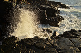 Waves splashing on the rocks on sunset