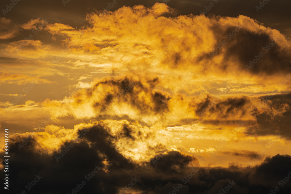 Dramatic clouds illuminated rising of sun in sky to change weather. Natural meteorology background. Soft focus, blurred motion. Heavenly landscape image ready for design, replace sky in photo editor.