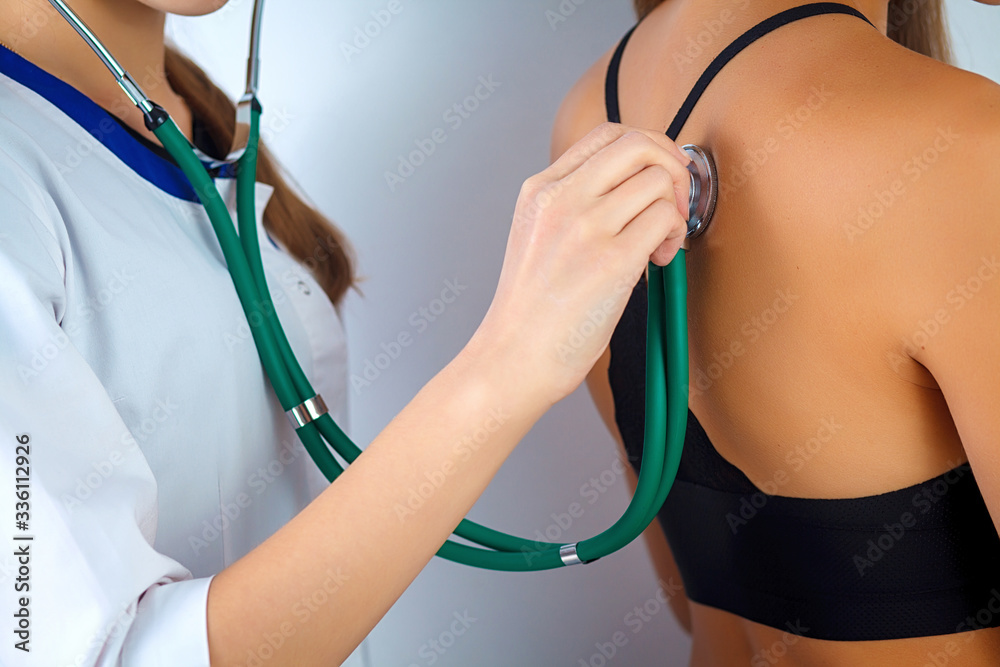 Doctor checking breathing with stethoscop of a female patient. Doctor  sitting near the patient and listening to the noise in his organism using a  stethoscope. Close-up. Stock Photo | Adobe Stock