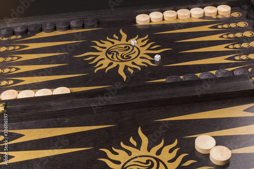 Backgammon. Board game. White cubes and chips on a blackboard.  Dice on backgammon board game. Selective focus. Playing leisure games photo