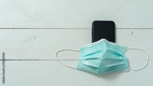Medical mask on the phone. Shot from above on a white background photo
