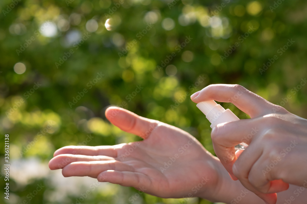 Hand of Asian woman applying the alcohol spray with greenery background. Closed up alcohol spray. Killing the virus. Hand of Asian woman applying the alcohol spray with greenery background. Closed up alcohol spray. Killing the virus.