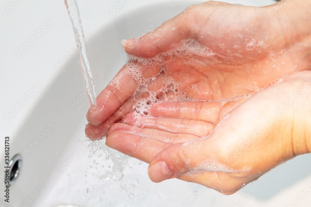 woman washes hands under the tap close up