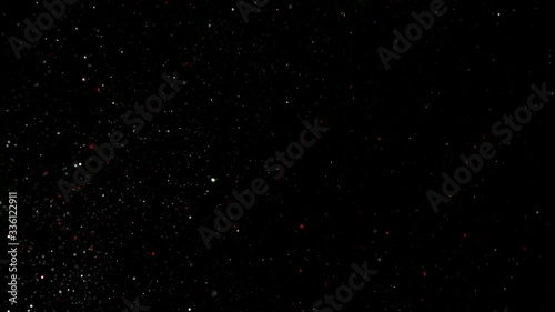 Falling flying Golden confetti. Abstract background with golden shiny sparkling sparkles. Particles of shiny dust sparkles. Flying and flickering particles of light. black background in 4K Loopable