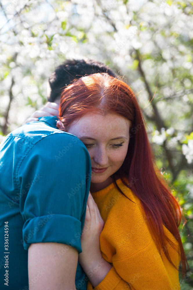 Fototapeta premium Young couple walking in spring garden.