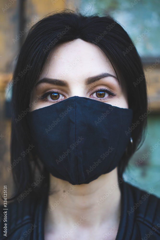 Fashion styled young girl in black medical mask and black jacket. Coronavirus covid-19 epidemic pandemic concept. People wear mask for protection. Close up portrait Fashion styled young girl in black medical mask and black jacket. Coronavirus covid-19 epidemic pandemic concept. People wear mask for protection. Close up portrait