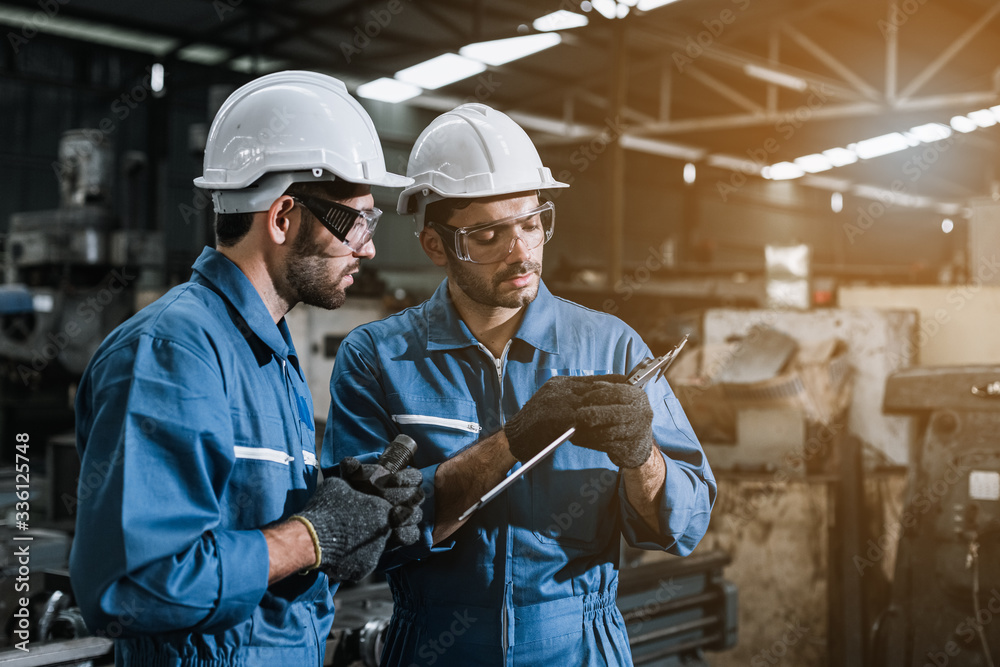 Engineer men wearing uniform safety workers perform maintenance in factory working machine lathe metal. Engineer men wearing uniform safety workers perform maintenance in factory working machine lathe metal.