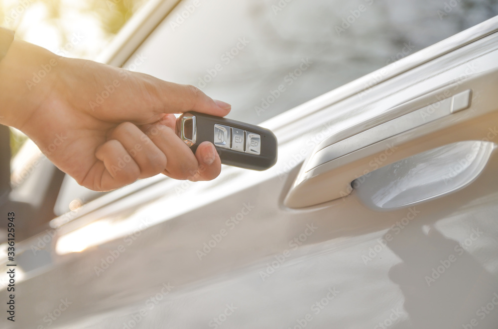 Car remote control by smart key, Hand holding smart key to lock doors of white car