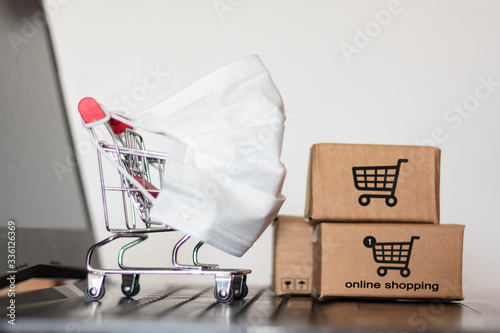 Shopping cart and carton boxes on laptop