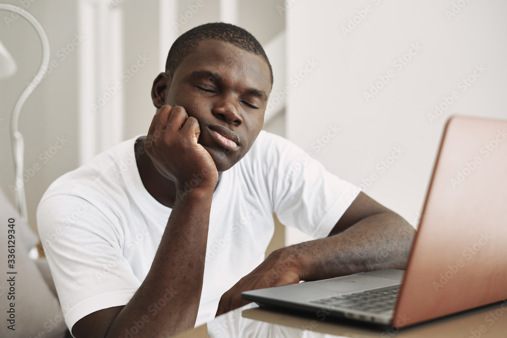 A man of African appearance at home in front of a laptop relaxing A man of African appearance at home in front of a laptop relaxing