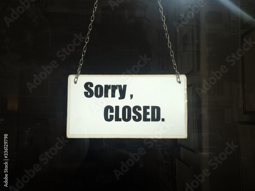 Lockdown, shutdown. Closed sign of commercial shop in shutdown, lockdown with Sorry closed typography on cardboard with metal strings hanging in window