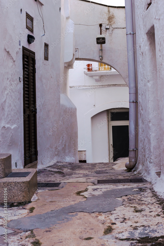 Naklejka premium Old narrow town street in historic center of Ostuni, Italy