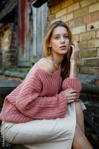 attractive young long haired woman in pink sweater posing  © smmartynenko