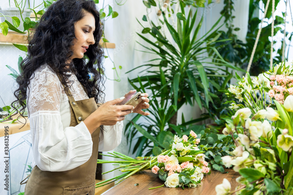 Attractive young woman florist is working in a flower shop. Attractive young woman florist is working in a flower shop.