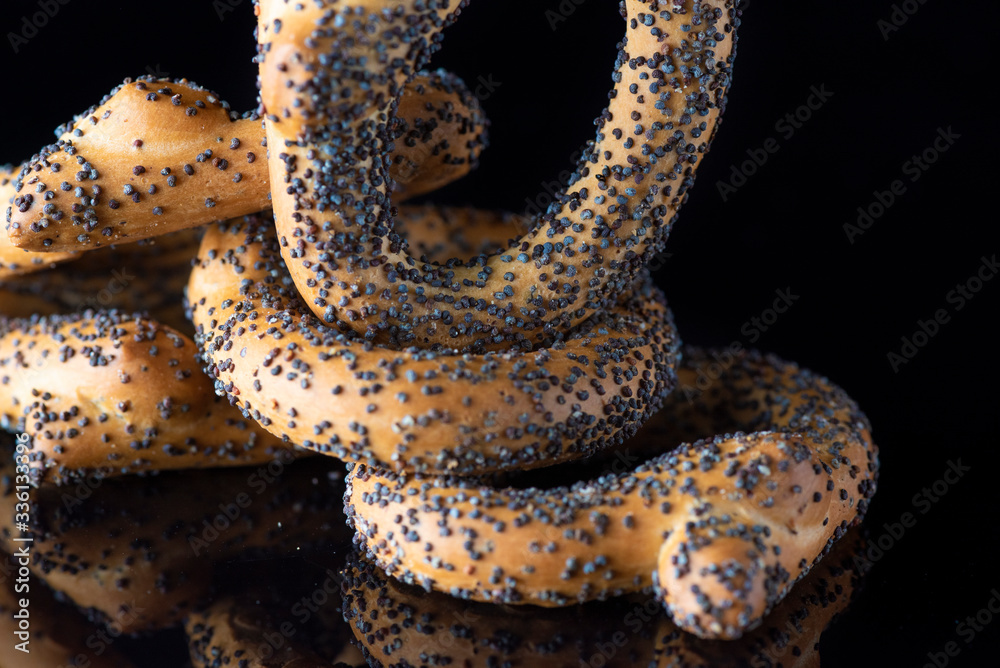Obraz premium Bagels with poppy seeds on a dark background. Photographed close-up.
