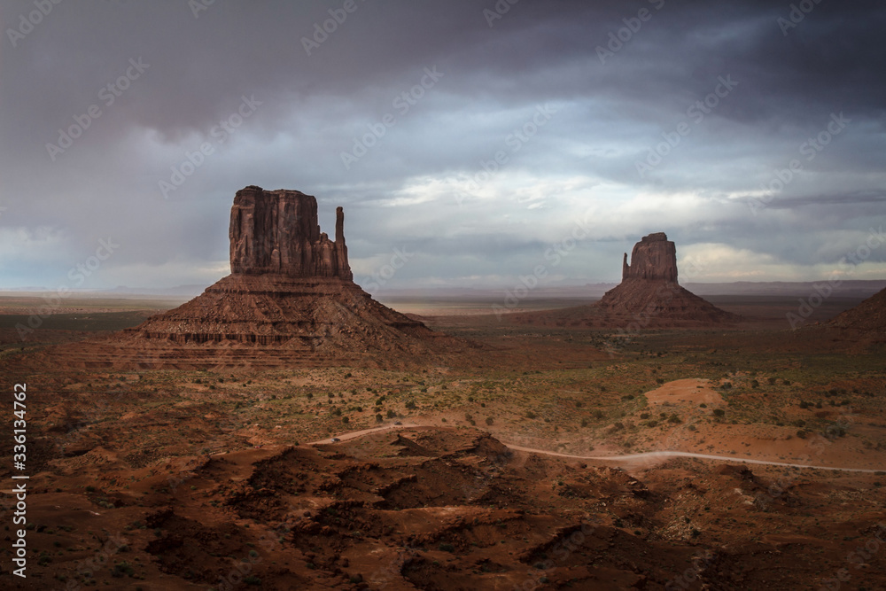 An incoming storm in the background of the scenic view of The Mittens and Merrick Butte from John Wayne's Point in the Oljato Navajo Monument Valley, Arizona, USA