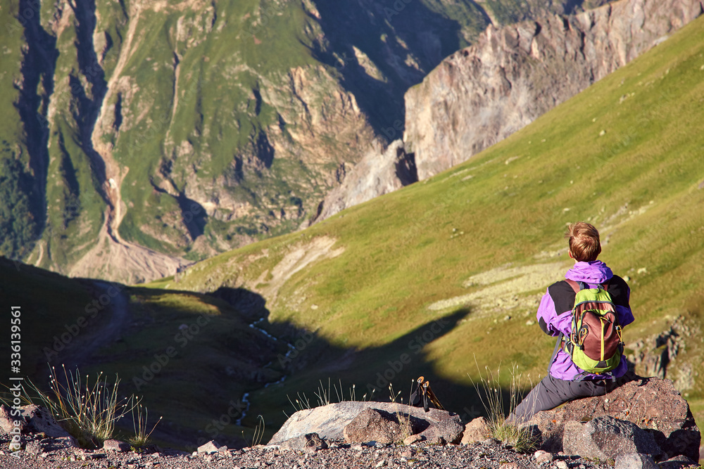 Fototapeta premium climber on trail in the mountains. a man with a backpack in a hike.