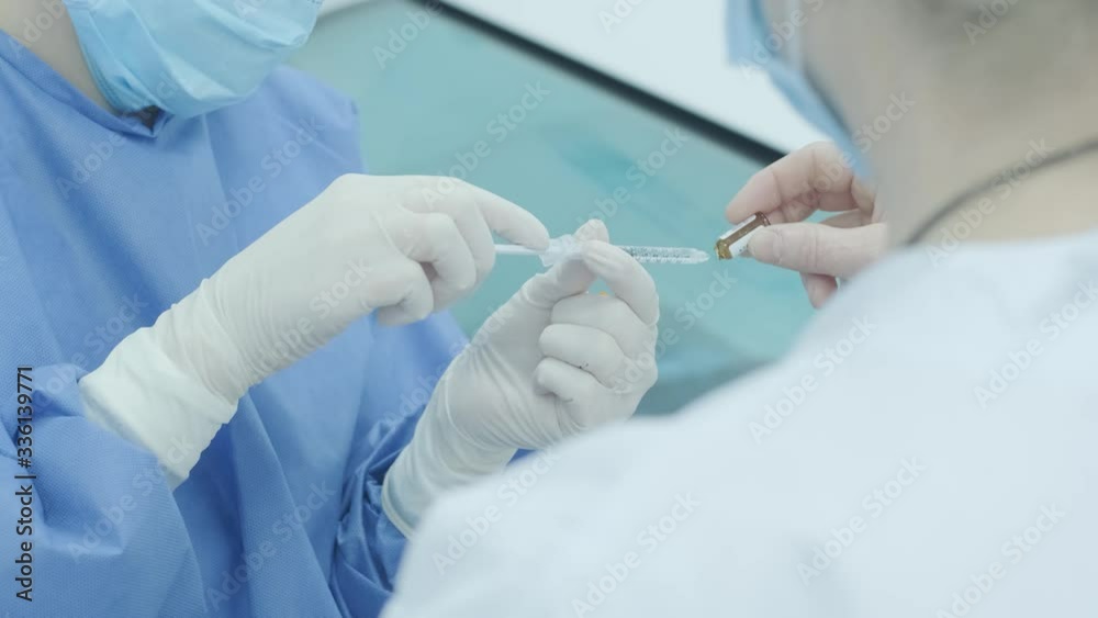 Doctor filling syringe with medication in the hospital, closeup. Vaccination and immunization. Anesthesia Doctor filling syringe with medication in the hospital, closeup. Vaccination and immunization. Anesthesia