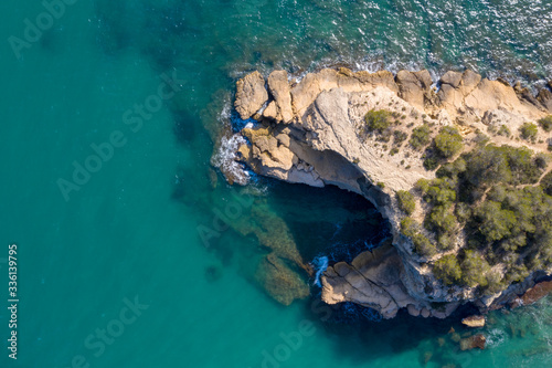 Aerial drone top-down view of calm turquoise water and rocks on the beautiful coast of Spain on the east side