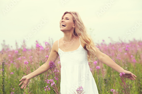 outdoor portrait of a beautiful middle aged blonde woman. attractive sexy girl in a field with flowers.
