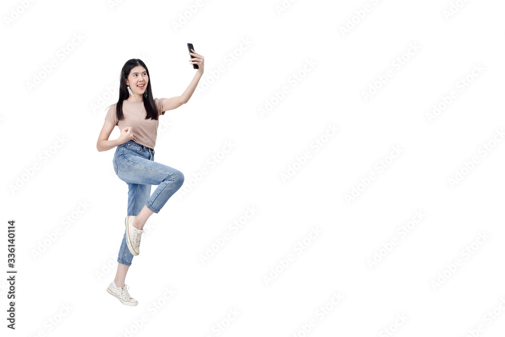 Fototapeta premium Cheerful woman jumping holding smartphone