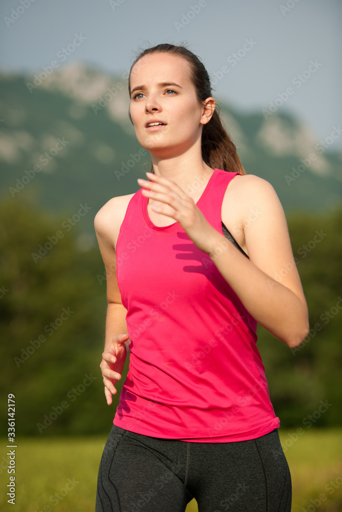 Beautiful young woman workout outdoor runs across meadow in early summer Beautiful young woman workout outdoor runs across meadow in early summer
