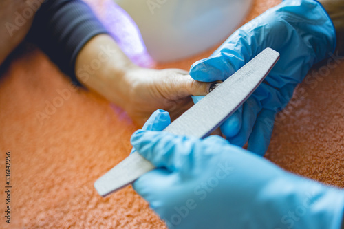 Manicurist paints nails in body care studio