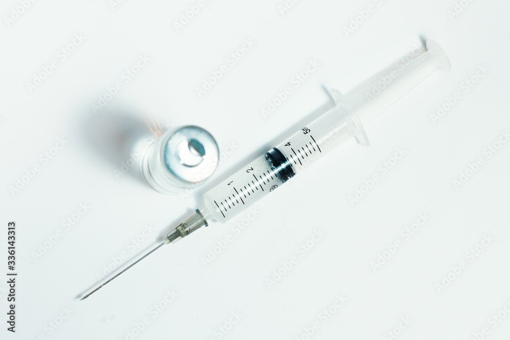 Glass medicine bottle with vaccine injection fluid with aluminium cap and syringe for vaccination, Coronavirus Covid-19 concept. Glass medicine bottle with vaccine injection fluid with aluminium cap and syringe for vaccination, Coronavirus Covid-19 concept.