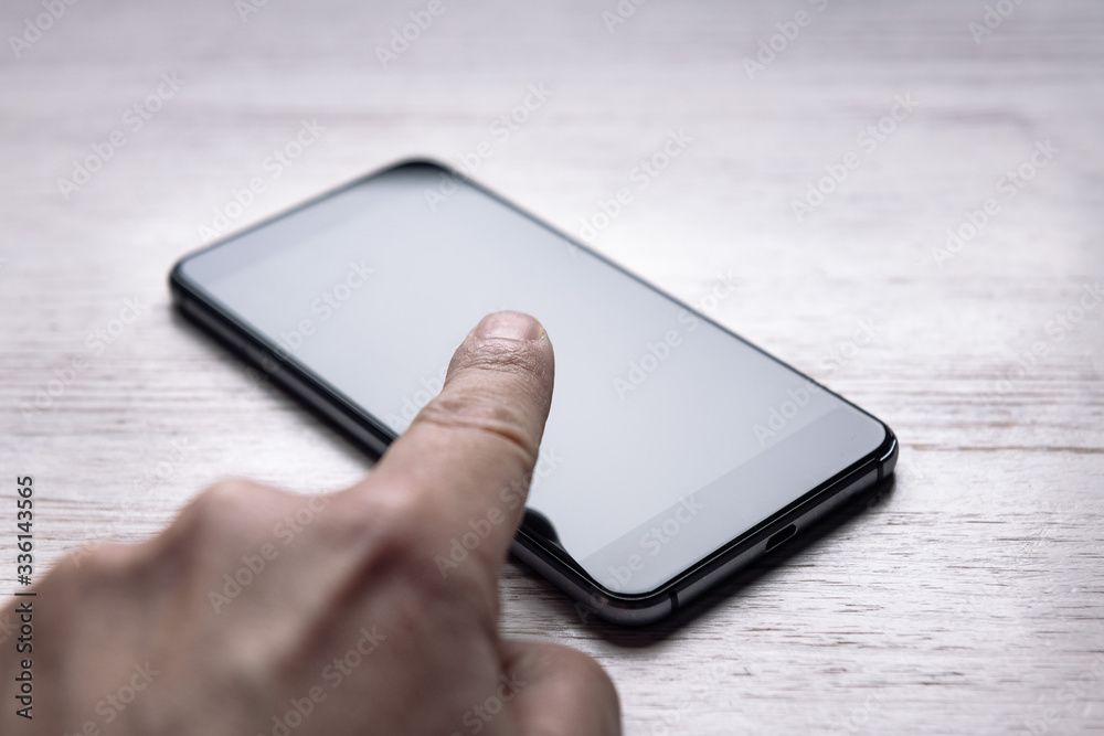 finger touching the screen of a smart phone finger touching the screen of a smart phone