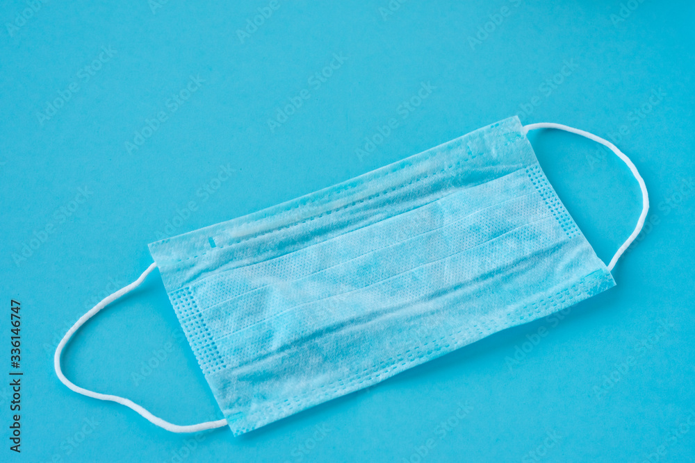 Medical mask for health protection and health care against viruses and bacteria on blue background. Masks for prevention of being ill Medical mask for health protection and health care against viruses and bacteria on blue background. Masks for prevention of being ill