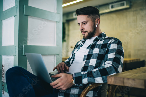 Bilde på lerret Pensive hipster guy concentrated on learning and watching webinar of online cour