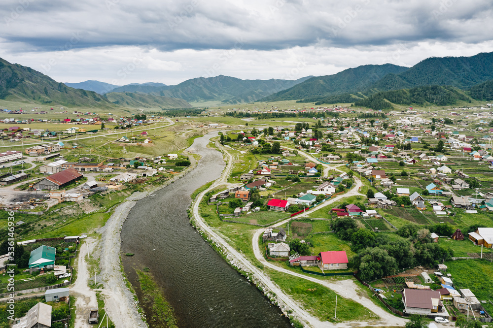 Ursul River and Onguday village in green valley of Altai Mountains, panoramic aerial view. Rural scenery in Altai Republic, Siberia, Russia