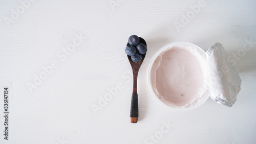 Blueberry yogurt on a white wooden table. Fresh yogurt. Healthy eating concept. High Resolution Product. View from above